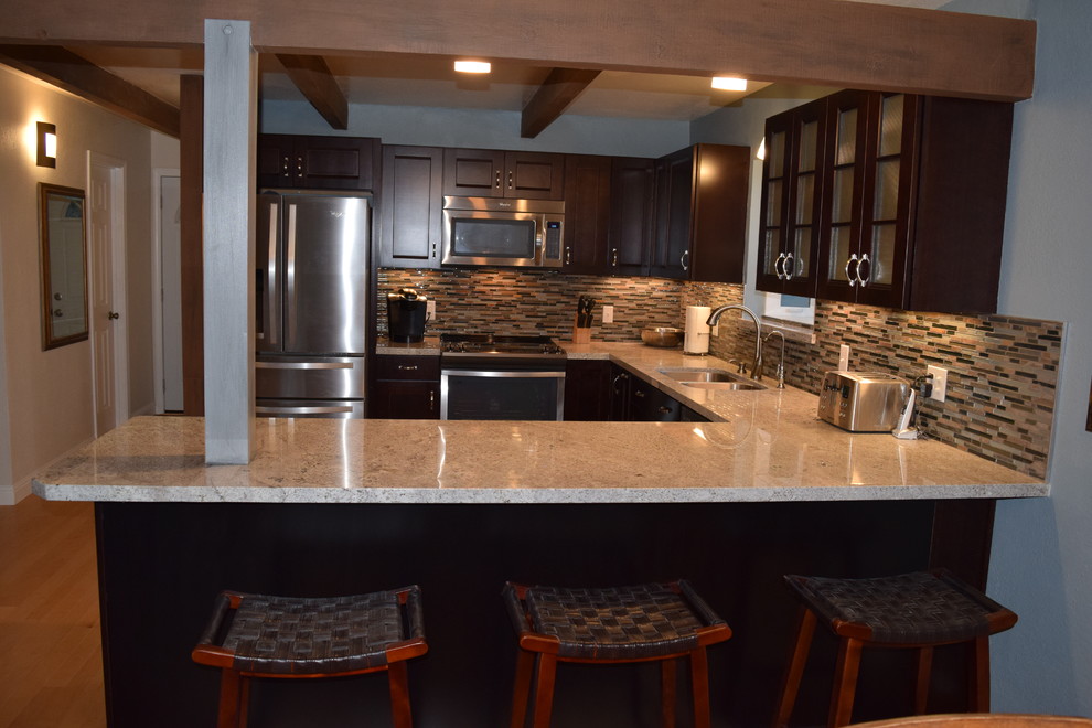 Eat-in kitchen - mid-sized rustic u-shaped light wood floor eat-in kitchen idea with a double-bowl sink, recessed-panel cabinets, dark wood cabinets, granite countertops, multicolored backsplash, stainless steel appliances and a peninsula