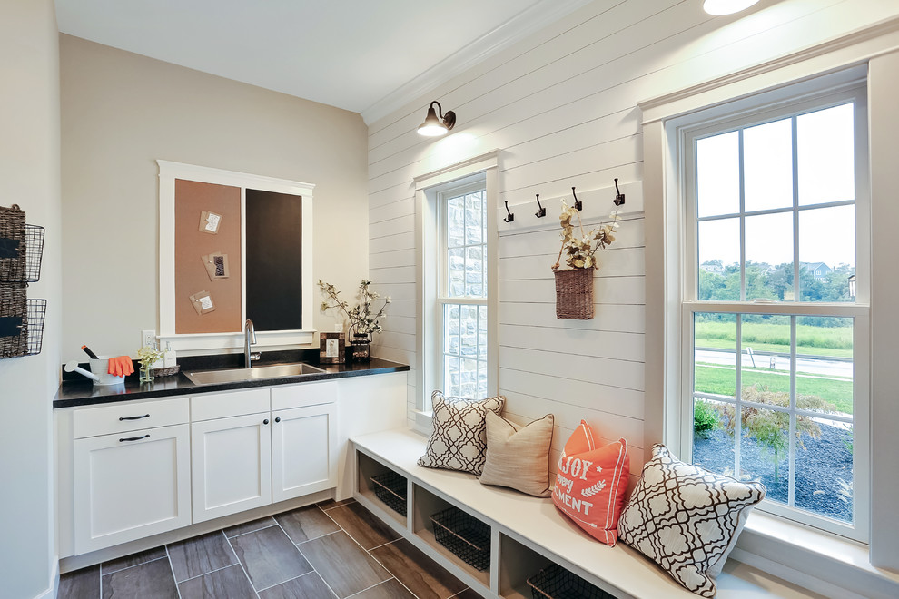 Photo of a large country mudroom in Other with beige walls, ceramic floors and a single front door.