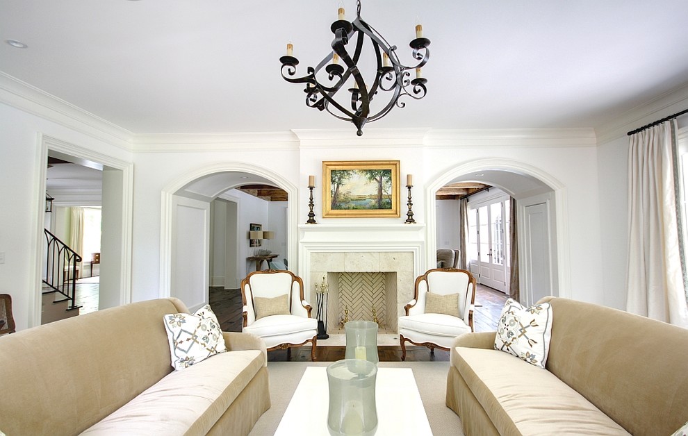 This is an example of a traditional living room in Atlanta with white walls, a standard fireplace and no tv.