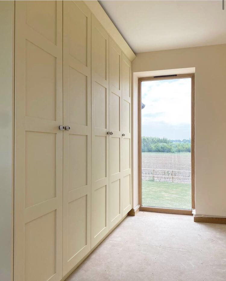 Exemple d'une armoire encastrée chic de taille moyenne avec un placard à porte shaker, des portes de placard grises, moquette et un sol multicolore.