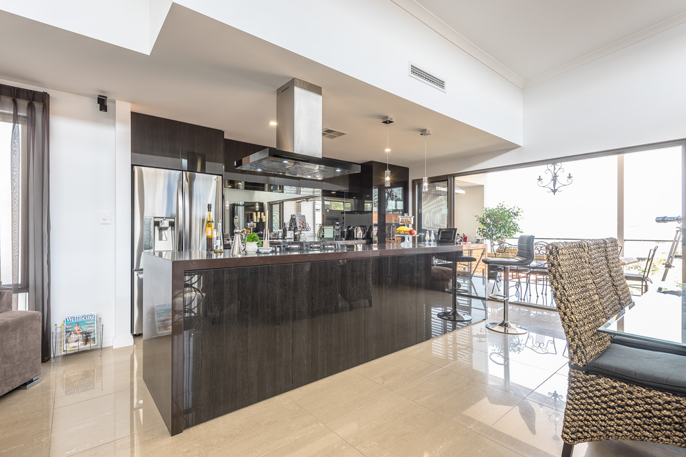 Mid-sized contemporary galley eat-in kitchen in Perth with an integrated sink, flat-panel cabinets, dark wood cabinets, granite benchtops, glass sheet splashback, stainless steel appliances, travertine floors and with island.