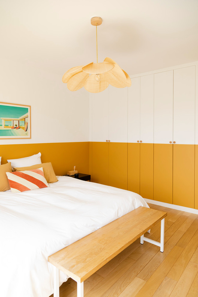 Aménagement d'une chambre parentale contemporaine de taille moyenne avec un mur multicolore, parquet clair, aucune cheminée et un sol beige.