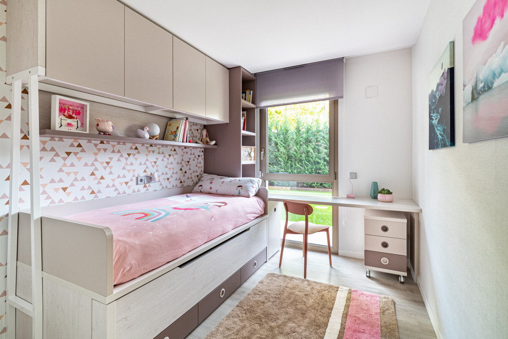 This is an example of a mid-sized contemporary kids' bedroom for girls in Barcelona with white walls and beige floor.