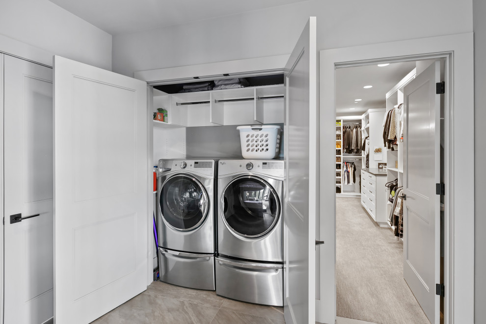 Foto di un'ampia lavanderia design con pareti grigie, moquette, pavimento grigio e travi a vista