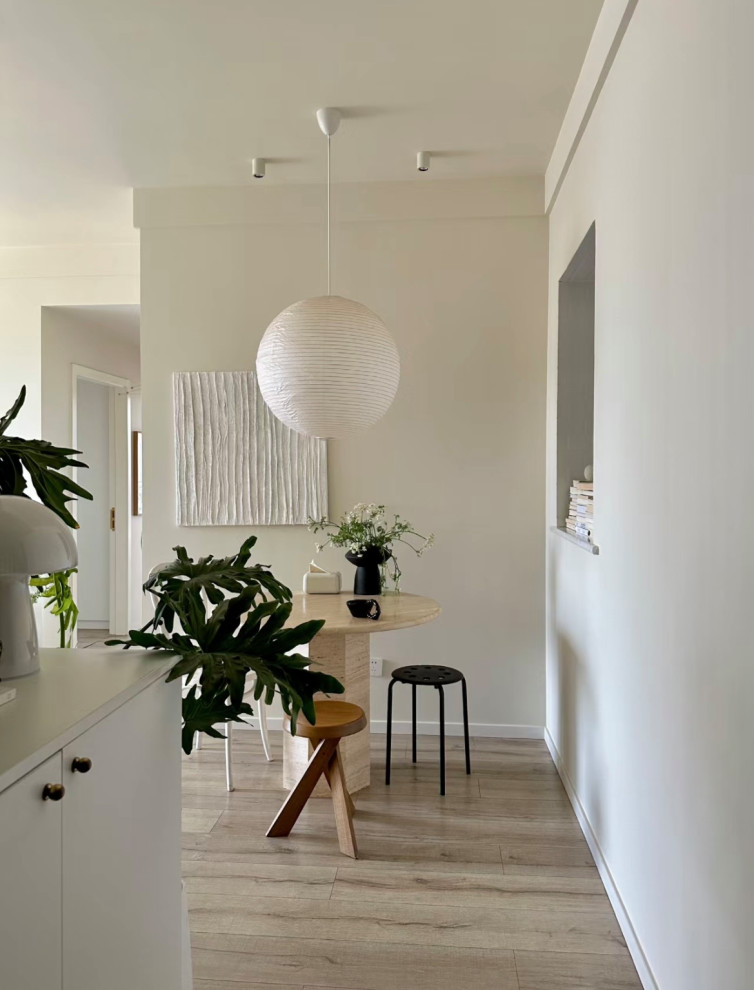 Inspiration pour une petite salle à manger ouverte sur la cuisine design avec un mur blanc, parquet clair et un sol jaune.
