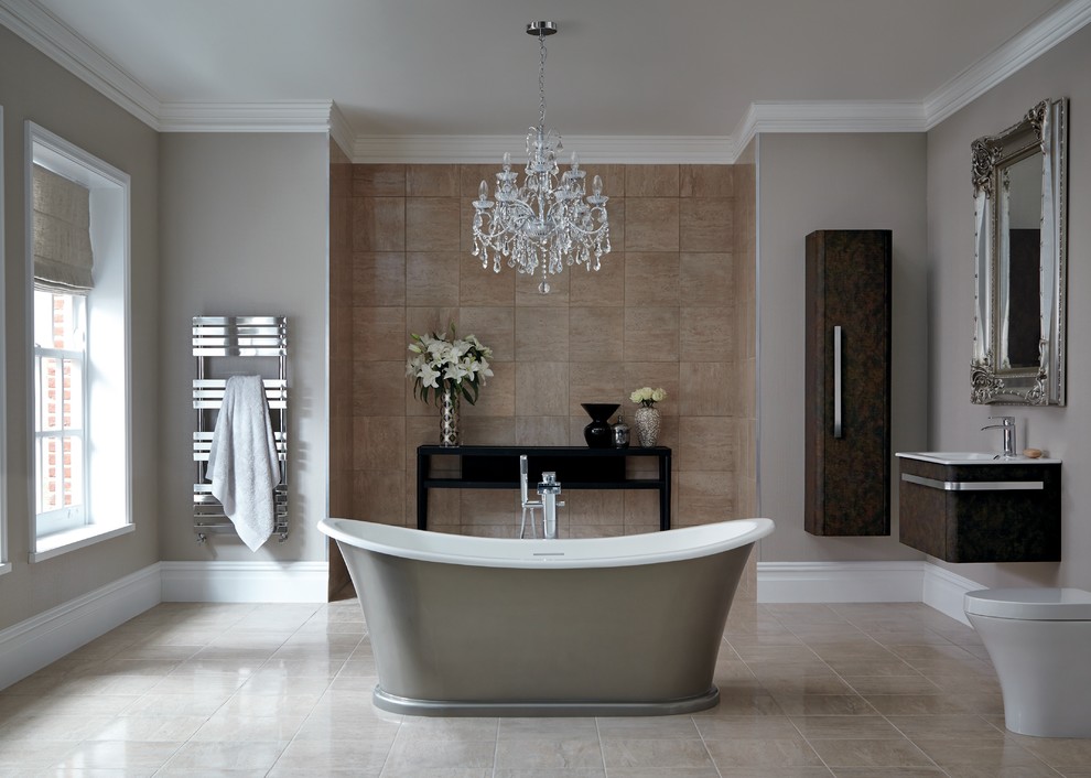 Expansive traditional master bathroom in Hertfordshire with a wall-mount sink, flat-panel cabinets, dark wood cabinets, a freestanding tub, a one-piece toilet, brown tile and grey walls.