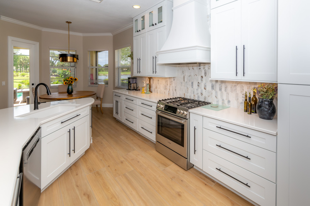 Foto på ett stort funkis vit kök, med en enkel diskho, skåp i shakerstil, vita skåp, bänkskiva i kvarts, flerfärgad stänkskydd, stänkskydd i marmor, rostfria vitvaror, klinkergolv i porslin, en halv köksö och flerfärgat golv