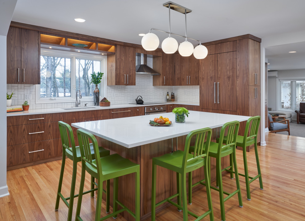 Inspiration for a mid-sized mid-century modern l-shaped medium tone wood floor and brown floor eat-in kitchen remodel in Minneapolis with a double-bowl sink, flat-panel cabinets, dark wood cabinets, quartz countertops, white backsplash, ceramic backsplash, stainless steel appliances, an island and white countertops