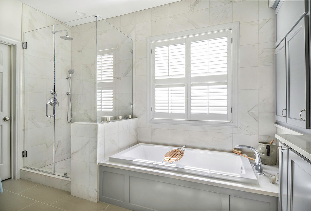 Photo of a mid-sized transitional master bathroom in Atlanta with recessed-panel cabinets, grey cabinets, engineered quartz benchtops, a drop-in tub, a corner shower, white tile, porcelain tile, white walls and porcelain floors.