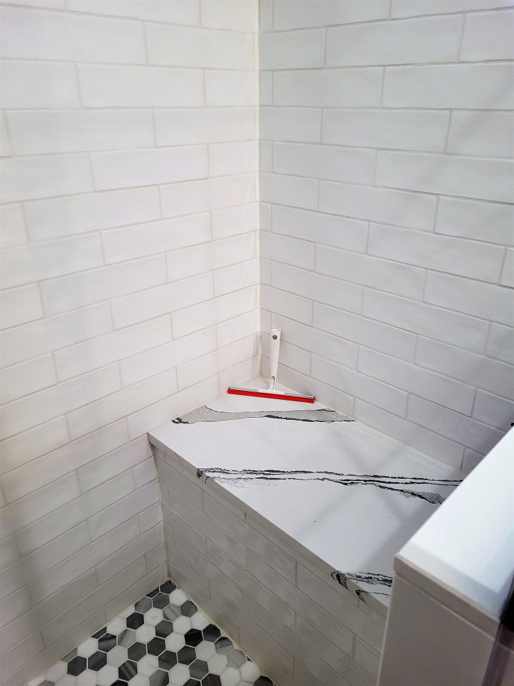 Aménagement d'une petite salle de bain classique avec un carrelage blanc, des carreaux de céramique, une cabine de douche à porte battante, un banc de douche, un sol en carrelage de terre cuite et un sol multicolore.