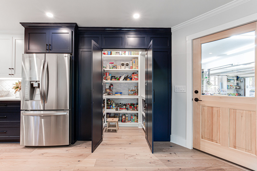 Example of a mid-sized farmhouse galley brown floor eat-in kitchen design in Atlanta with an undermount sink, shaker cabinets, blue cabinets, quartz countertops, white backsplash, mosaic tile backsplash and stainless steel appliances