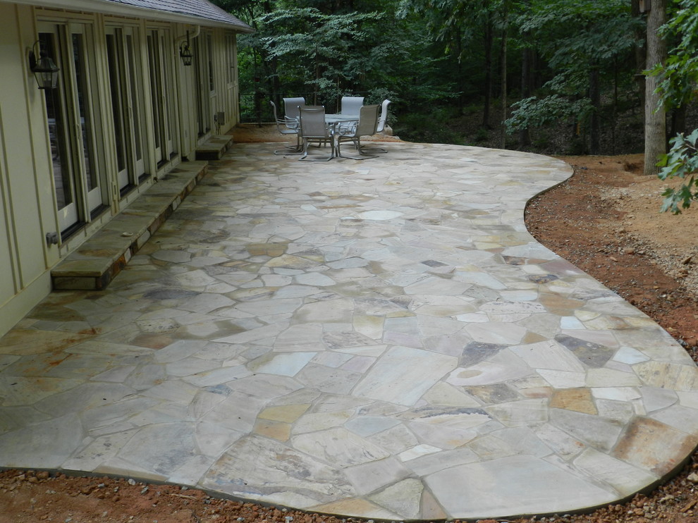 This is an example of a small mediterranean backyard patio in Raleigh with a vegetable garden, natural stone pavers and no cover.