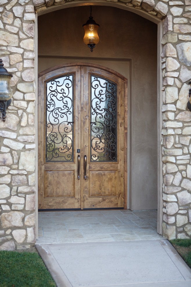 This is an example of a mid-sized mediterranean front door in San Diego with white walls, a double front door and a medium wood front door.