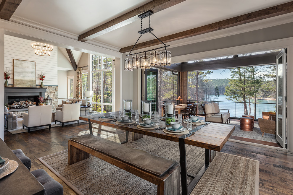 Inspiration for a large rustic medium tone wood floor kitchen/dining room combo remodel with beige walls and a stone fireplace