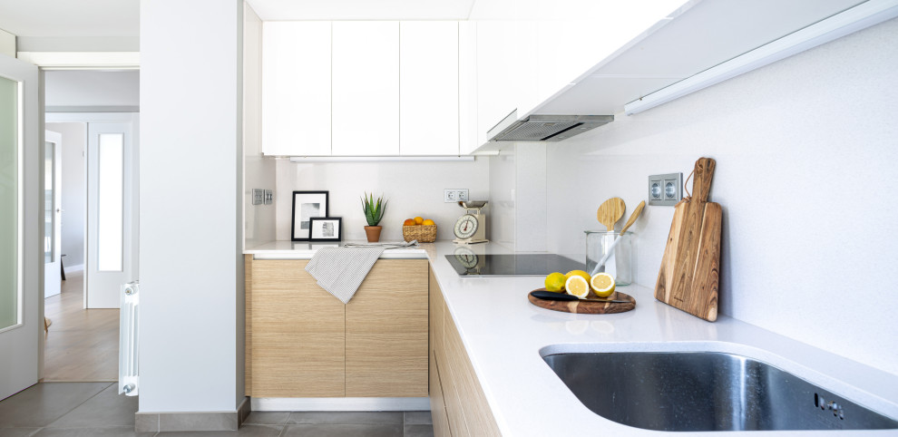 Ejemplo de cocina minimalista de tamaño medio con armarios con paneles lisos, puertas de armario de madera clara, encimera de cuarzo compacto, salpicadero blanco y encimeras blancas