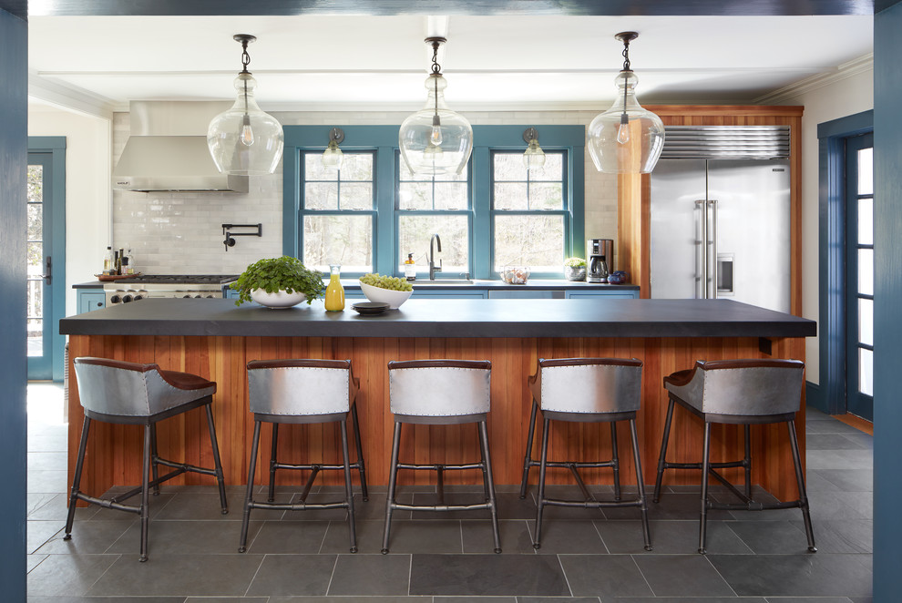 Design ideas for a mid-sized country single-wall eat-in kitchen in Boston with a single-bowl sink, recessed-panel cabinets, blue cabinets, limestone benchtops, subway tile splashback, stainless steel appliances, slate floors, with island, grey floor and white splashback.