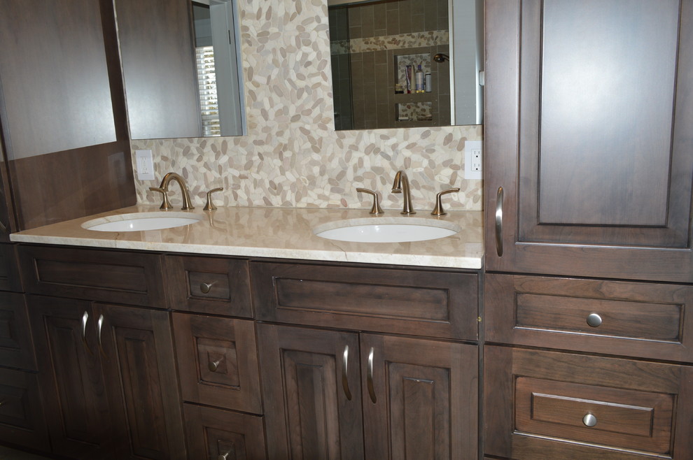 Inspiration for a mid-sized transitional master beige tile and cement tile bathroom remodel in Boston with raised-panel cabinets, dark wood cabinets, a hot tub, an undermount sink, beige countertops and quartzite countertops