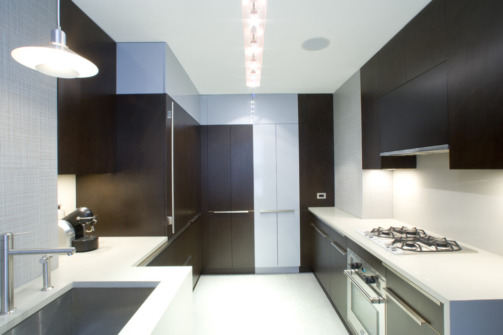 This is an example of a modern galley kitchen in New York with an undermount sink, flat-panel cabinets and dark wood cabinets.