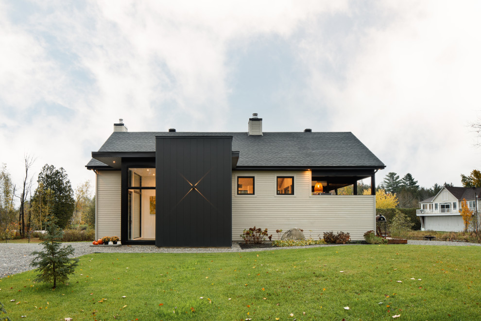 Inspiration for a mid-sized contemporary two-storey beige house exterior in Montreal with mixed siding, a gable roof, a shingle roof and a grey roof.