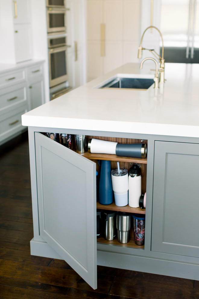 Eat-in kitchen - mid-sized transitional single-wall dark wood floor, brown floor and exposed beam eat-in kitchen idea with an undermount sink, shaker cabinets, white cabinets, quartz countertops, white backsplash, subway tile backsplash, stainless steel appliances, an island and white countertops