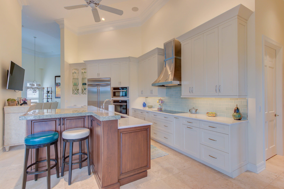 Example of a large transitional single-wall enclosed kitchen design with an undermount sink, flat-panel cabinets, white cabinets, quartz countertops, blue backsplash, stone tile backsplash, stainless steel appliances and an island