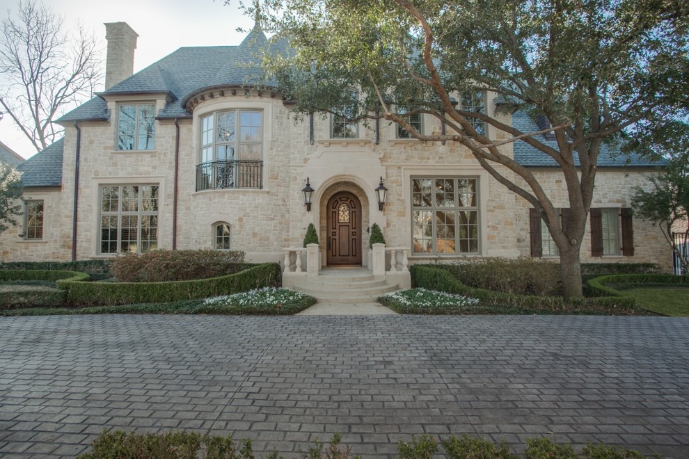 Inspiration for a large traditional three-storey beige house exterior in Dallas with stone veneer, a gable roof and a shingle roof.