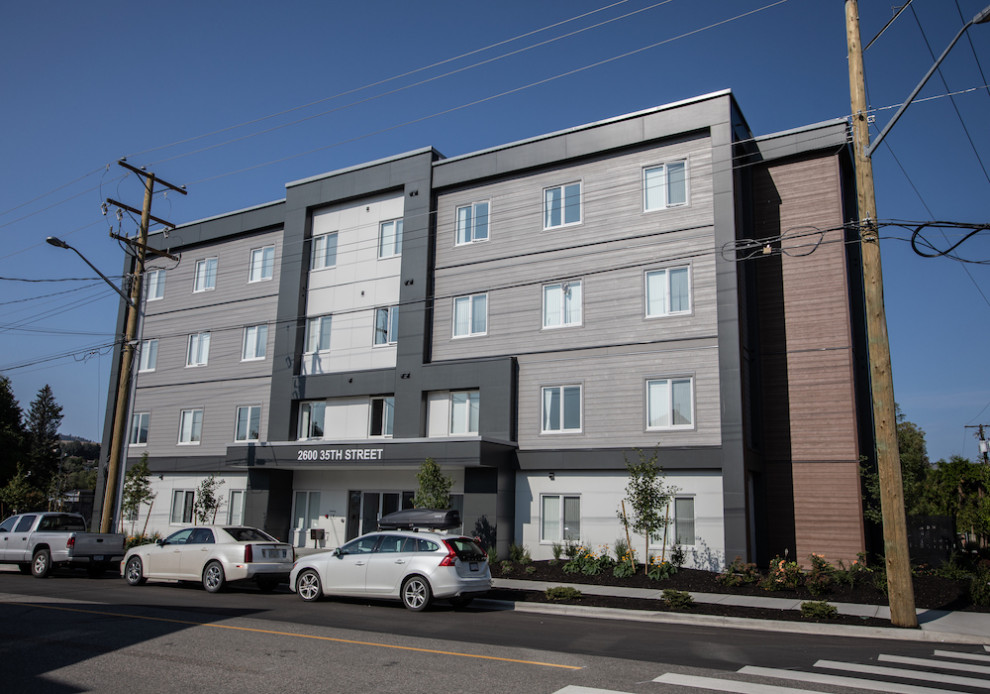 Large contemporary three-storey multi-coloured apartment exterior in Vancouver with mixed siding and a flat roof.