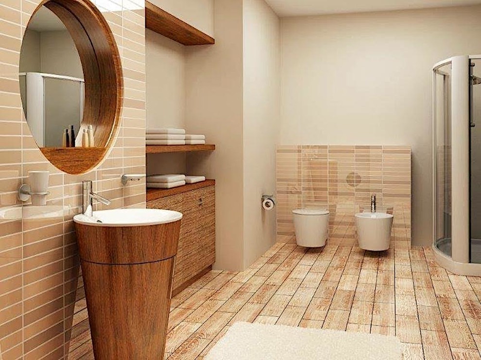 Photo of a modern bathroom in Other with furniture-like cabinets, medium wood cabinets, an alcove shower, a wall-mount toilet, beige tile, beige walls and a pedestal sink.