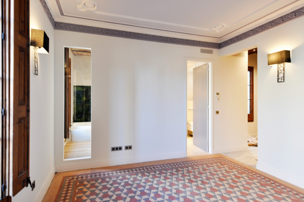 Ejemplo de dormitorio principal tradicional renovado grande sin chimenea con paredes blancas, suelo de baldosas de cerámica y suelo rojo
