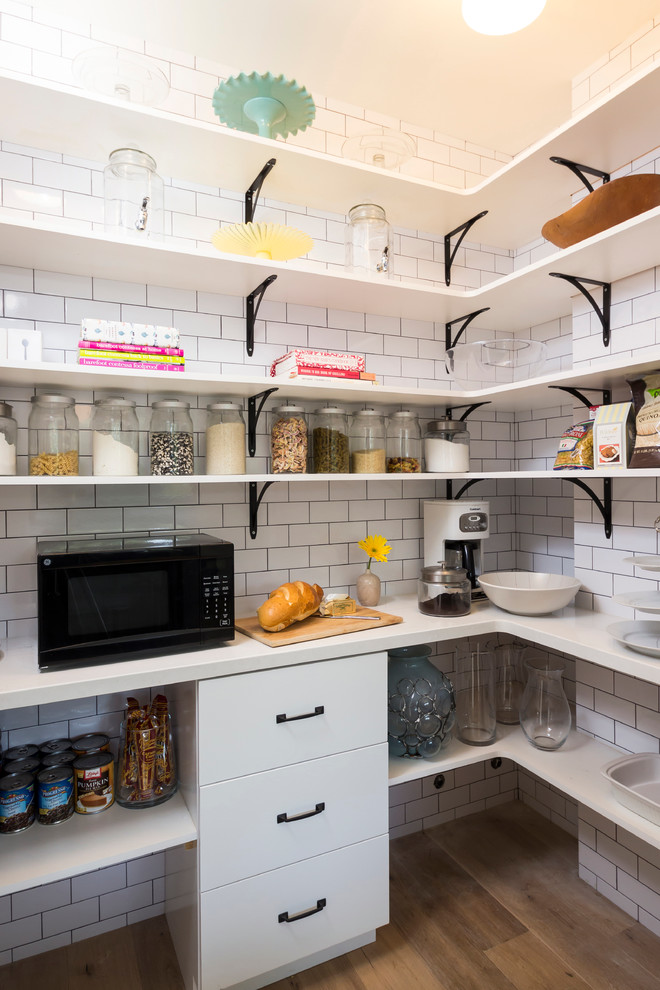 Design ideas for a transitional kitchen pantry in Los Angeles with white splashback, subway tile splashback and black appliances.