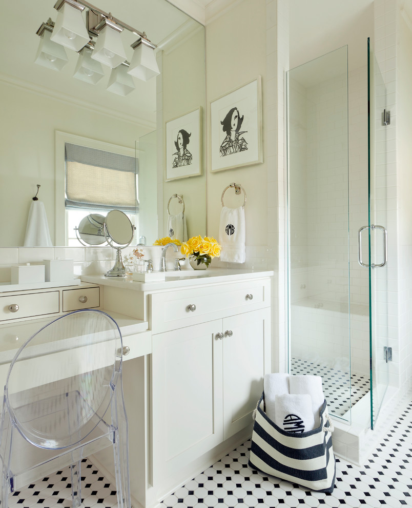 This is an example of a large transitional bathroom in Little Rock with recessed-panel cabinets, white cabinets, a freestanding tub, an alcove shower, a one-piece toilet, white tile, ceramic tile, white walls, ceramic floors, an undermount sink and marble benchtops.