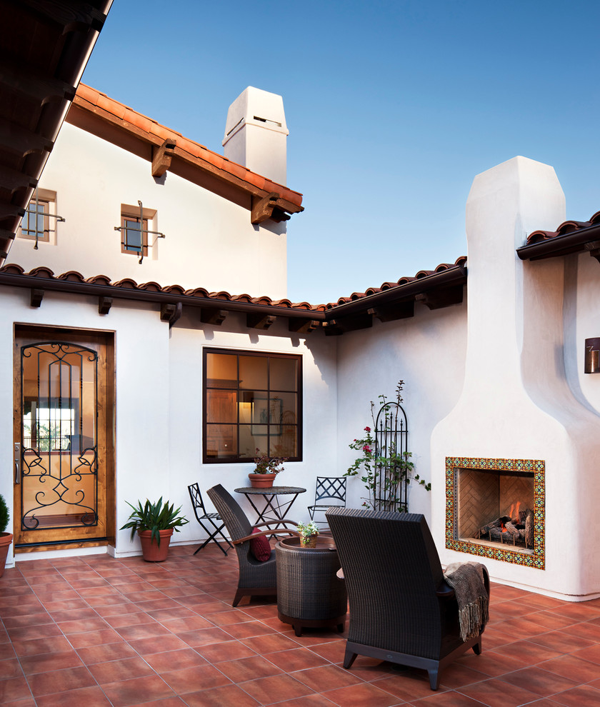 Large courtyard patio in San Diego with a fire feature, natural stone pavers and no cover.
