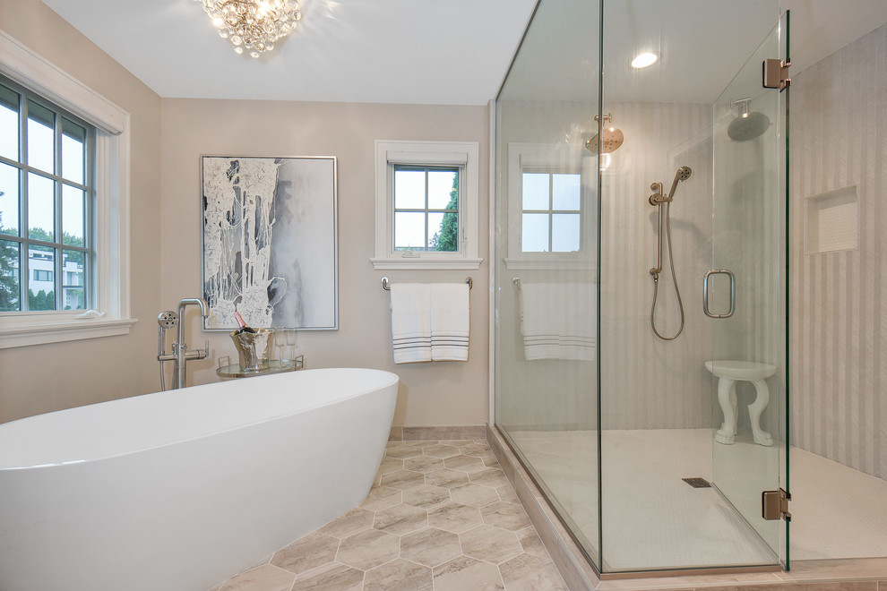 Photo of a large transitional master bathroom in Minneapolis with flat-panel cabinets, white cabinets, a freestanding tub, a corner shower, a two-piece toilet, white tile, glass sheet wall, brown walls, porcelain floors, an undermount sink, engineered quartz benchtops, multi-coloured floor, a hinged shower door and white benchtops.