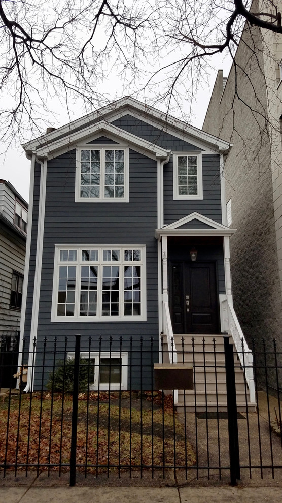 This is an example of a mid-sized traditional three-storey grey house exterior in Chicago with concrete fiberboard siding, a gable roof and a shingle roof.