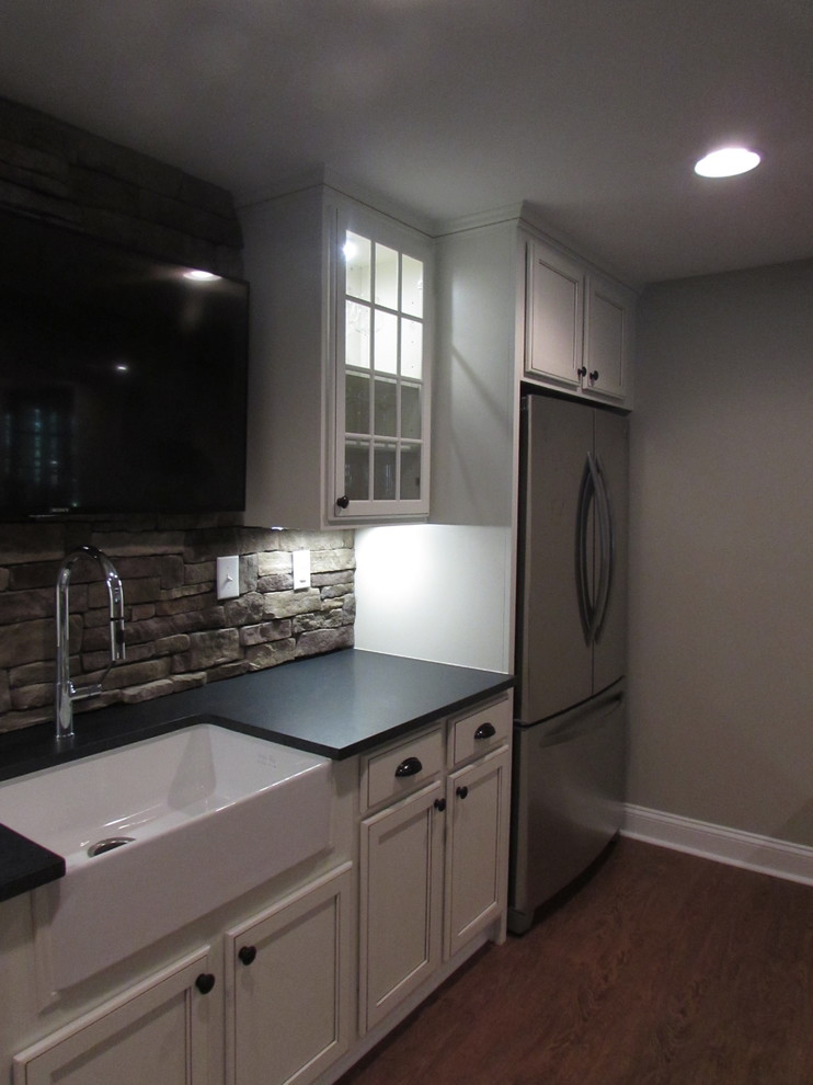 Basement - large walk-out vinyl floor basement idea with beige walls, a standard fireplace and a stone fireplace