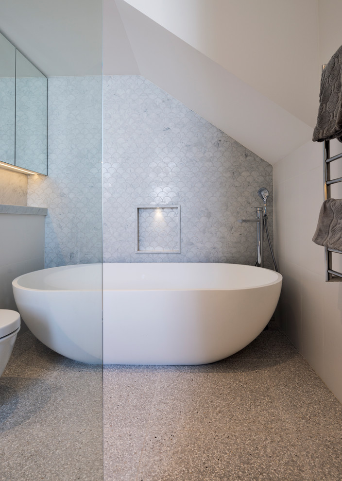 Mid-sized contemporary master bathroom in Sydney with glass-front cabinets, a freestanding tub, an open shower, a wall-mount toilet, gray tile, marble, white walls, marble floors, a wall-mount sink and marble benchtops.