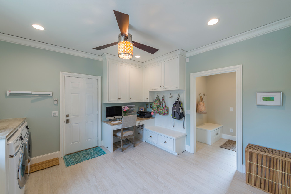 Photo of a large transitional utility room in Dallas with shaker cabinets, white cabinets and a side-by-side washer and dryer.