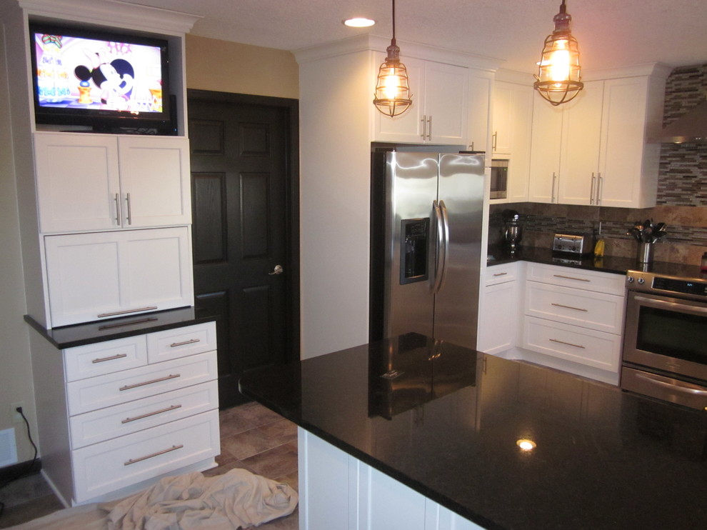 Inspiration for a large transitional u-shaped ceramic tile enclosed kitchen remodel with a double-bowl sink, shaker cabinets, white cabinets, solid surface countertops, multicolored backsplash, stone tile backsplash, stainless steel appliances and a peninsula