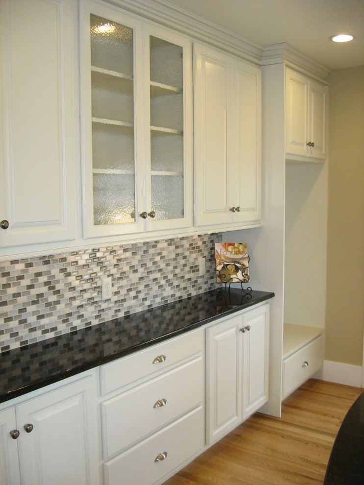 Enclosed kitchen - mid-sized transitional u-shaped dark wood floor enclosed kitchen idea in Denver with an undermount sink, raised-panel cabinets, white cabinets, quartzite countertops, multicolored backsplash, matchstick tile backsplash, stainless steel appliances and an island