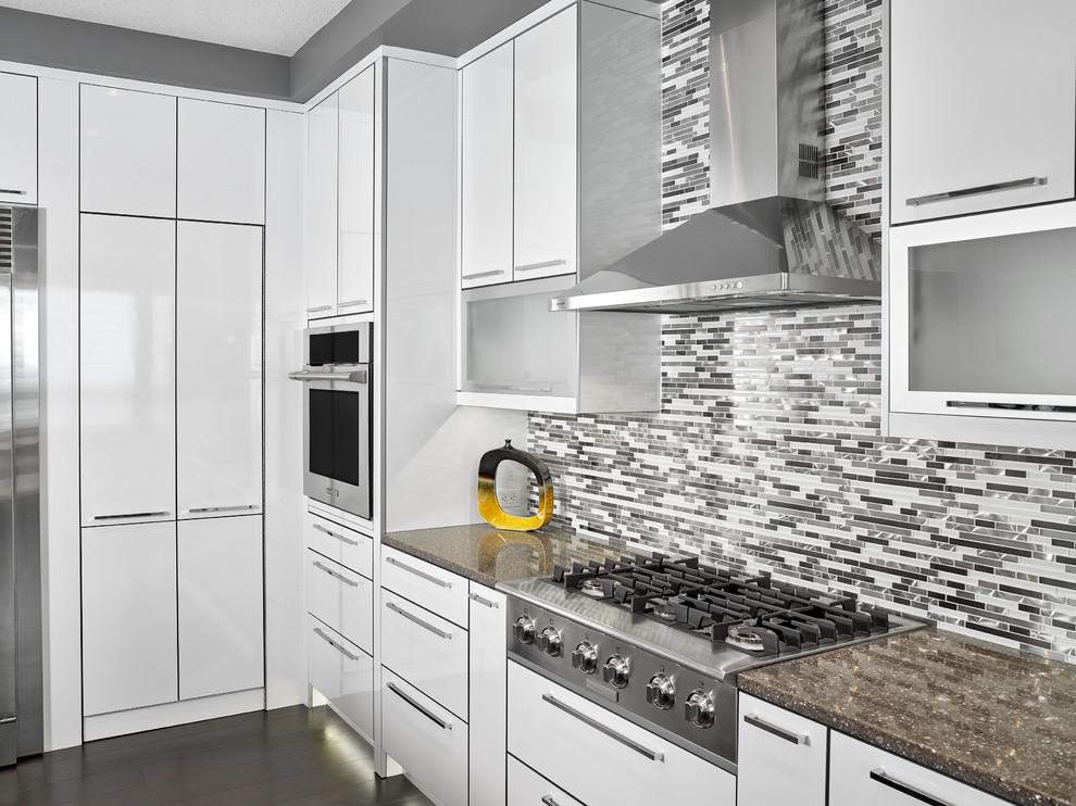 Photo of a large contemporary l-shaped eat-in kitchen in Edmonton with an undermount sink, flat-panel cabinets, white cabinets, quartz benchtops, multi-coloured splashback, mosaic tile splashback, stainless steel appliances and multiple islands.
