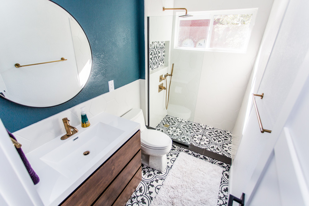 Design ideas for a small contemporary 3/4 bathroom in Austin with flat-panel cabinets, medium wood cabinets, an open shower, a one-piece toilet, blue tile, porcelain tile, blue walls, ceramic floors, an integrated sink, solid surface benchtops, white floor, an open shower and white benchtops.