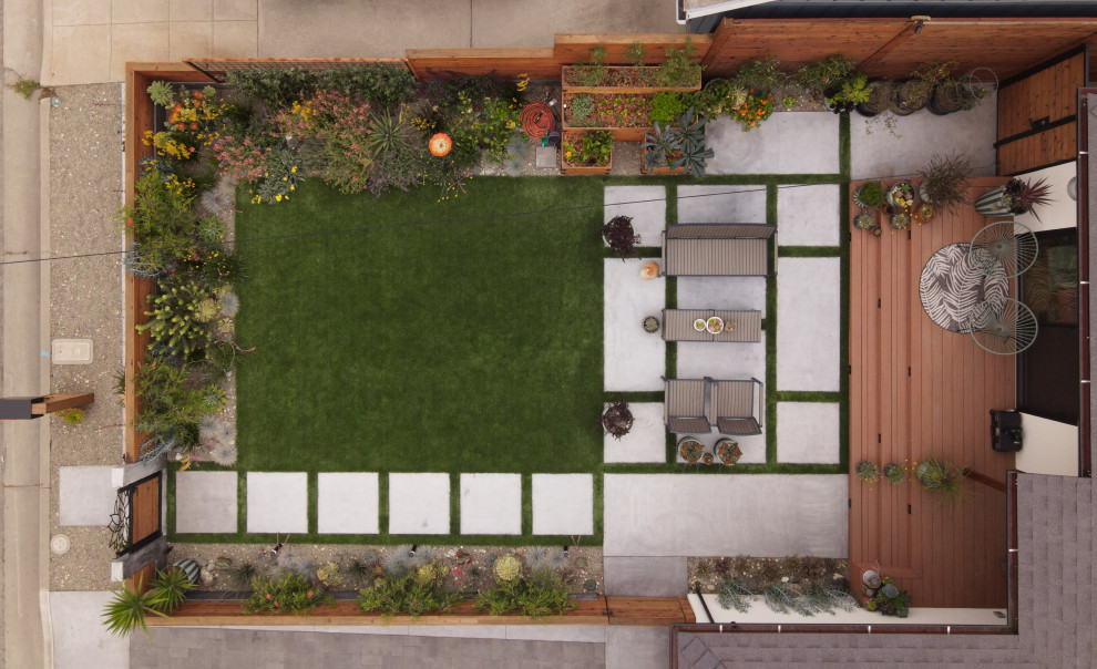 Foto di un giardino xeriscape moderno esposto in pieno sole di medie dimensioni e davanti casa in estate con un focolare, pavimentazioni in cemento e recinzione in legno