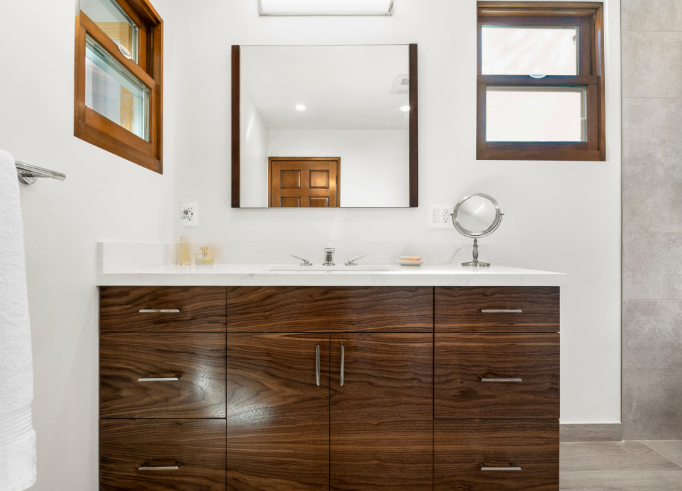 Design ideas for a large transitional master wet room bathroom in Los Angeles with flat-panel cabinets, medium wood cabinets, a freestanding tub, beige tile, porcelain tile, white walls, porcelain floors, engineered quartz benchtops, beige floor, an open shower and white benchtops.