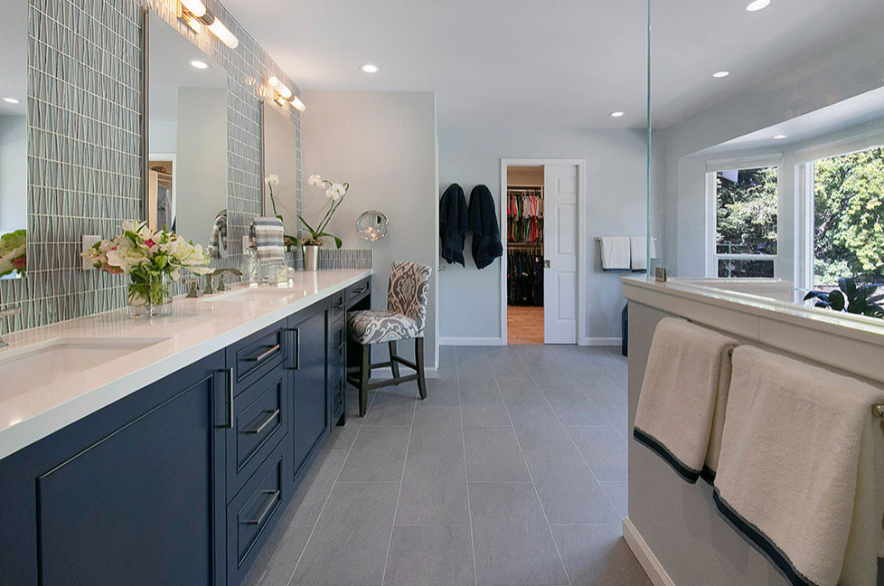 Large traditional ensuite bathroom in San Francisco with recessed-panel cabinets, blue cabinets, a corner shower, a two-piece toilet, blue tiles, glass tiles, grey walls, porcelain flooring, a submerged sink, engineered stone worktops, grey floors, a hinged door, white worktops, a shower bench, double sinks and a built in vanity unit.