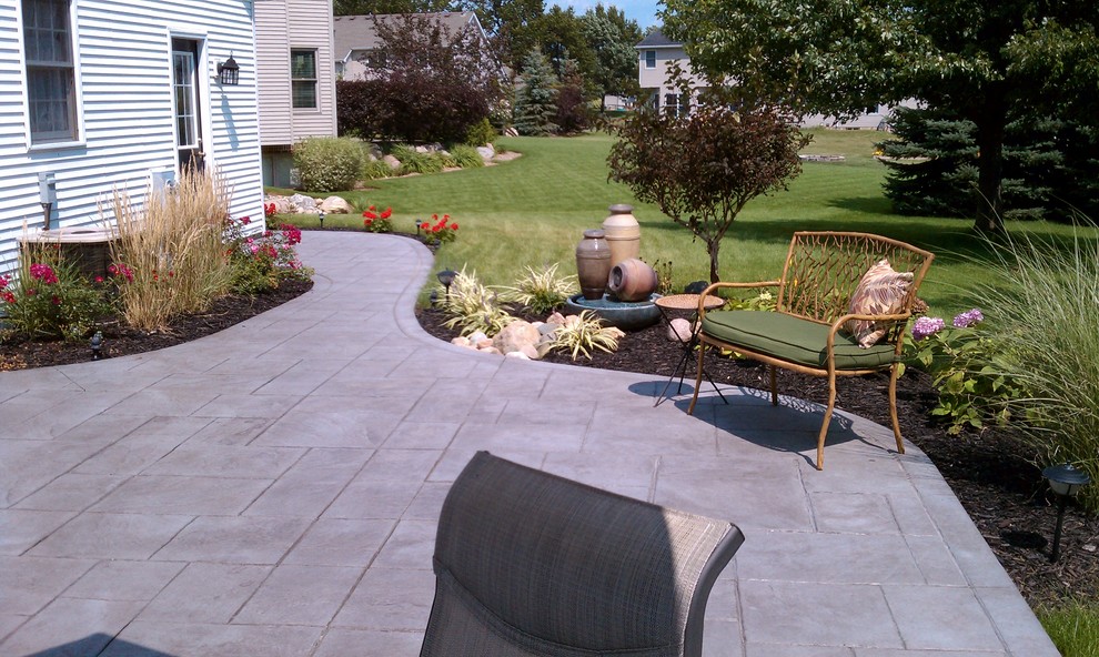 Inspiration for a small mediterranean backyard patio in Detroit with a water feature and stamped concrete.