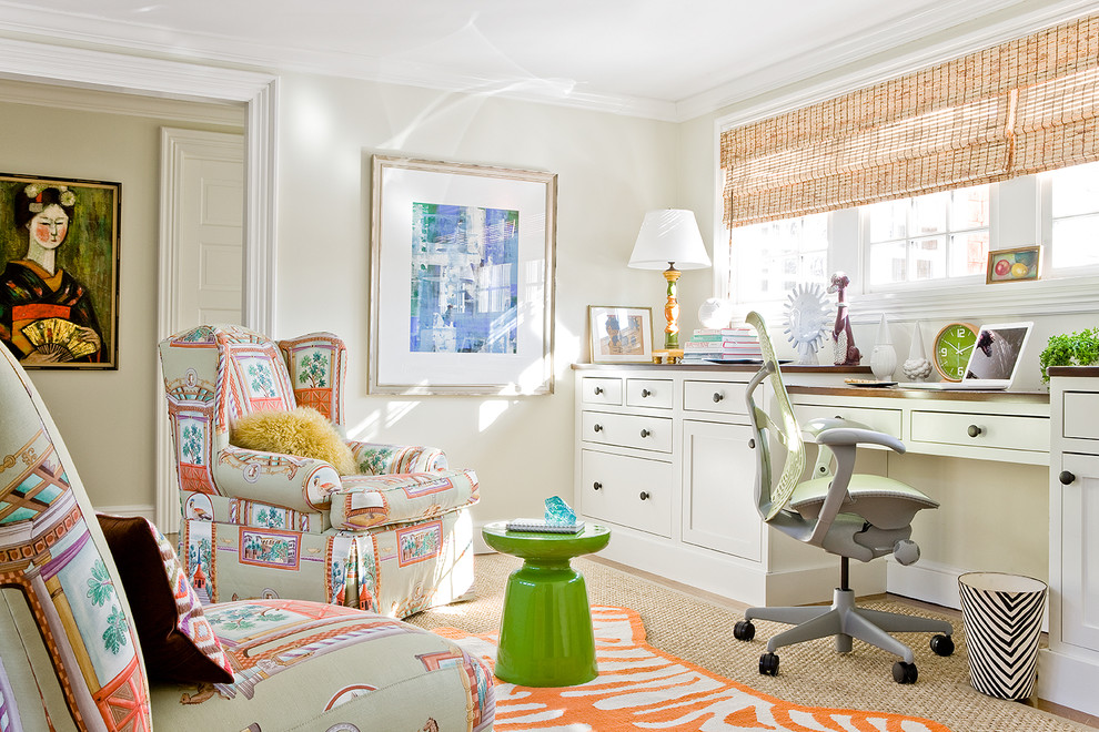 This is an example of a transitional home office in Boston with a built-in desk and grey walls.