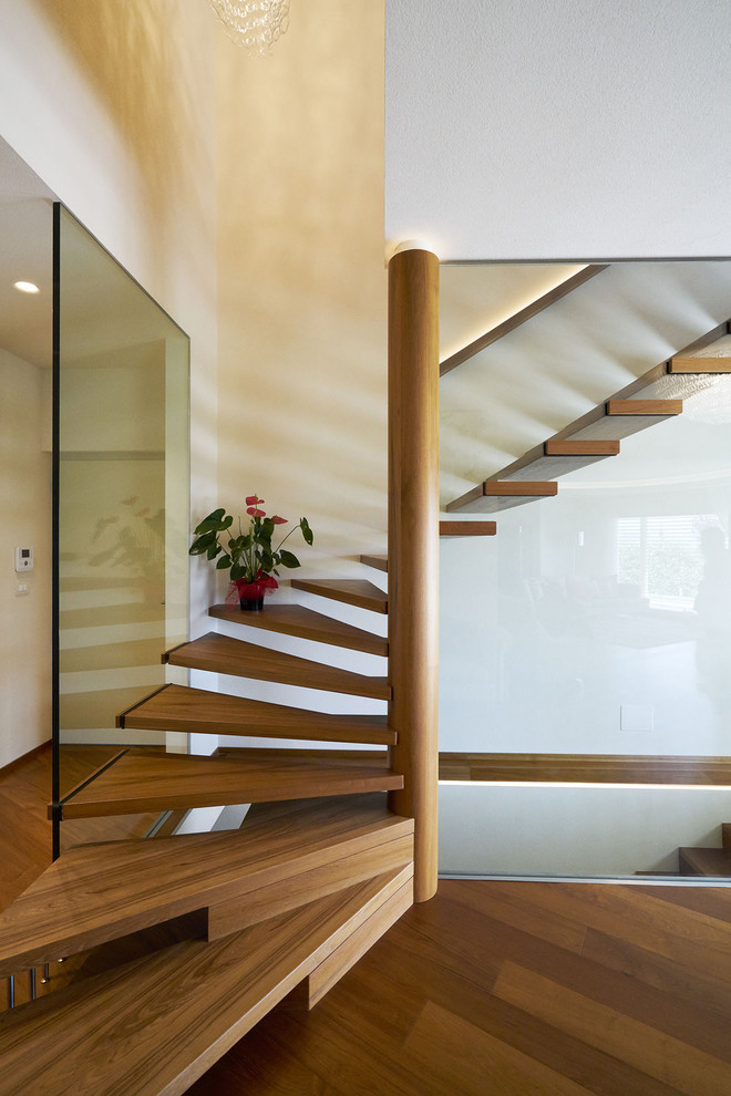 This is an example of a contemporary wood l-shaped staircase with open risers and mixed railing.