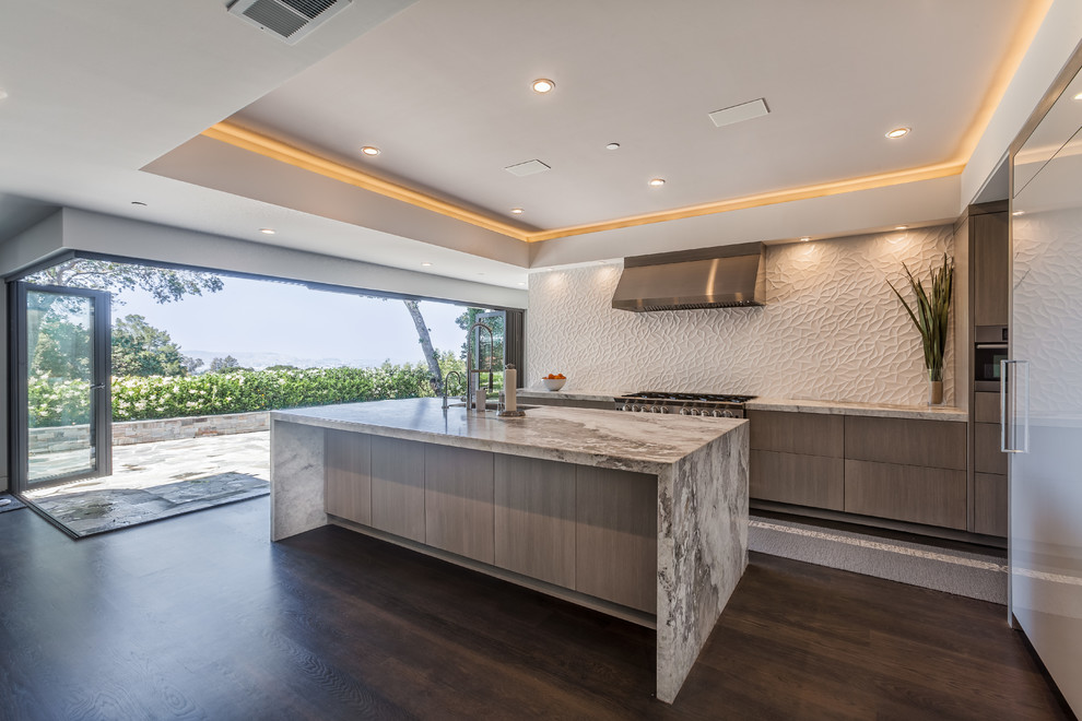 This is an example of a modern kitchen in San Francisco with a drop-in sink, flat-panel cabinets, medium wood cabinets, quartzite benchtops, white splashback, ceramic splashback, panelled appliances, dark hardwood floors and with island.