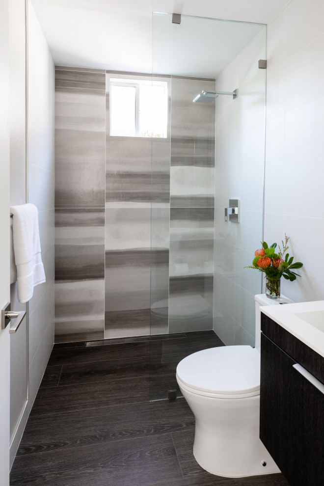 This is an example of a small contemporary 3/4 bathroom in San Diego with flat-panel cabinets, brown cabinets, an open shower, a one-piece toilet, brown tile, porcelain tile, beige walls, porcelain floors, an integrated sink, engineered quartz benchtops, brown floor, an open shower, white benchtops, a single vanity and a floating vanity.