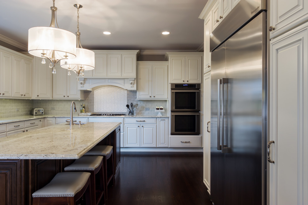 Large transitional u-shaped dark wood floor kitchen photo in Chicago with a double-bowl sink, raised-panel cabinets, white cabinets, granite countertops, gray backsplash, subway tile backsplash, stainless steel appliances and an island